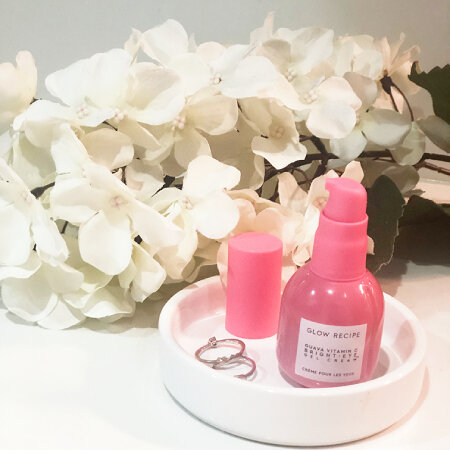 The Glow Recipe Guava Vitamin C Bright-Eye Gel Cream with flowers and silver rings in a coaster