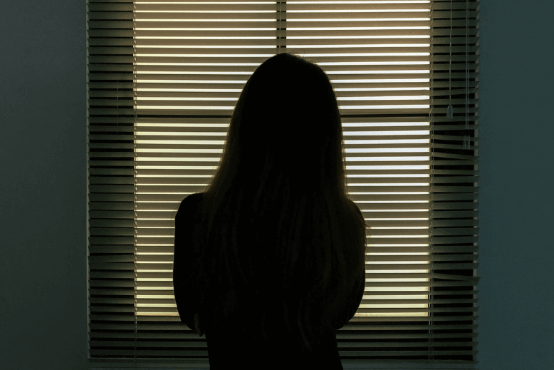 Girl alone Girl standing alone in a darklit room